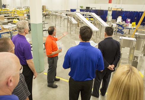 Dorner employee guiding tour of professional and showcasing conveyor belts