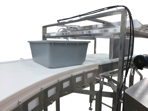 Bucket on top of AquaPruf 7400 Series stainless steel conveyor