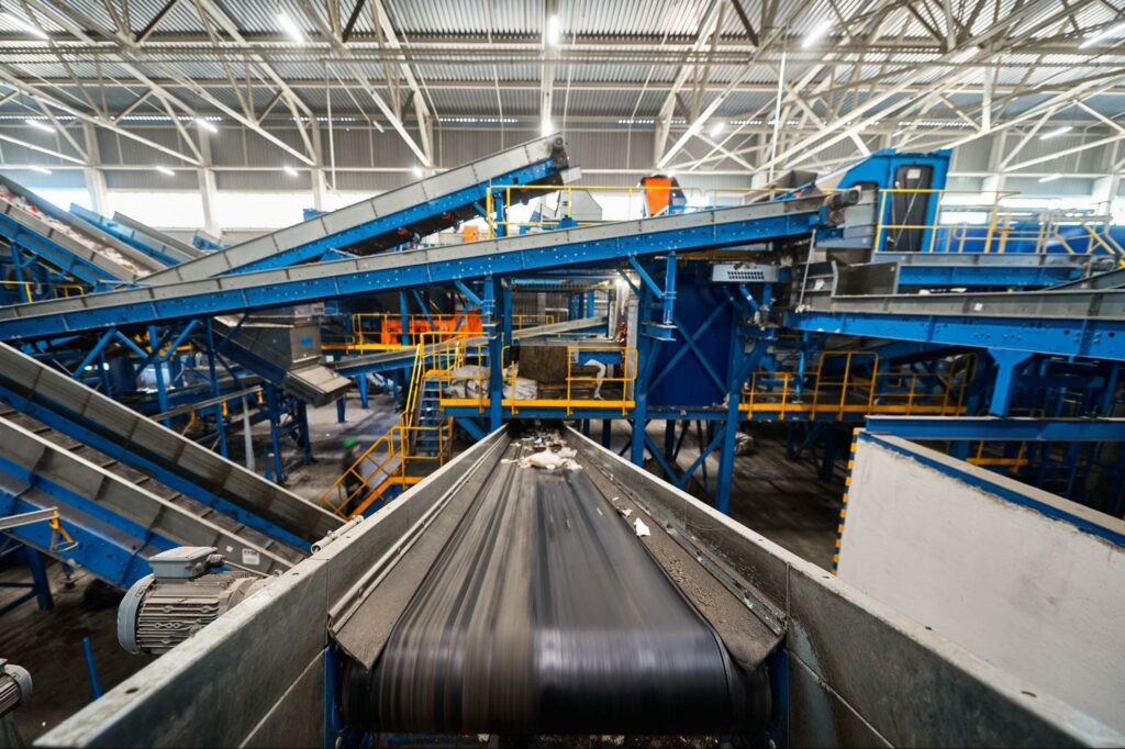 A series of conveyor belts in operation inside a large warehouse. 