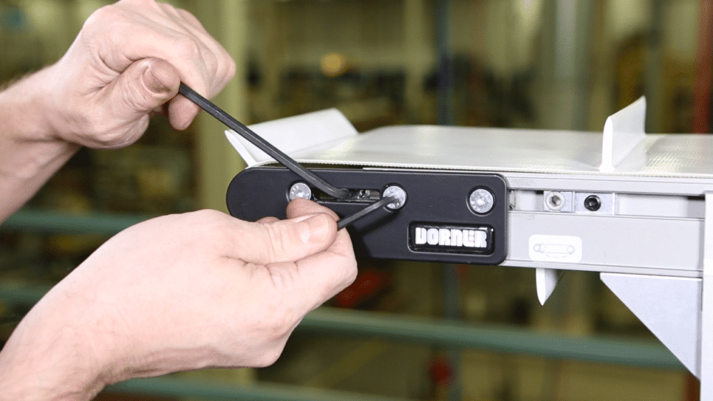 An operator adjusts the belt tension of a Dorner conveyor belt.