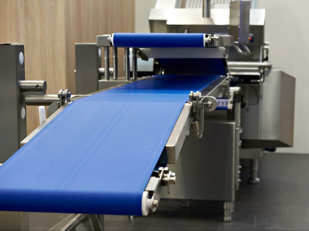 A blue sanitary conveyor belt stretched for proper tension. 