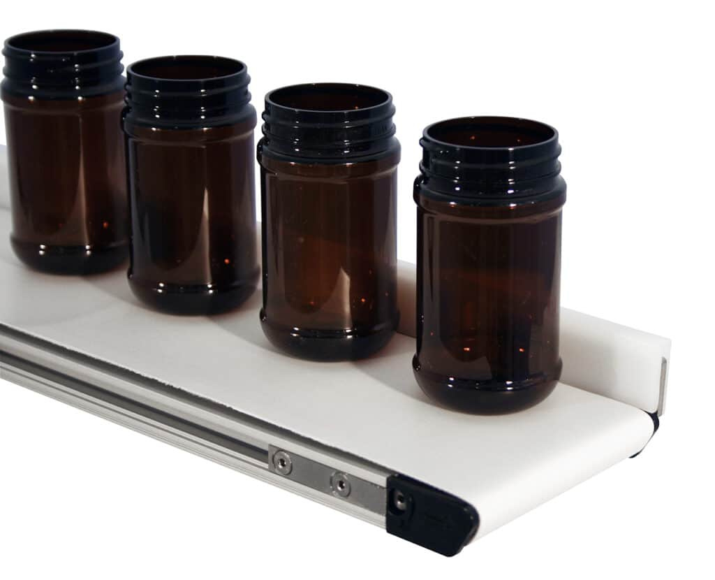 A mini conveyor from Dorner transports empty brown bottles.